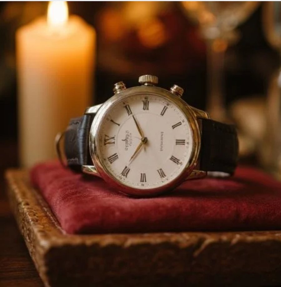 A warm, candlelit photograph of a vintage wristwatch